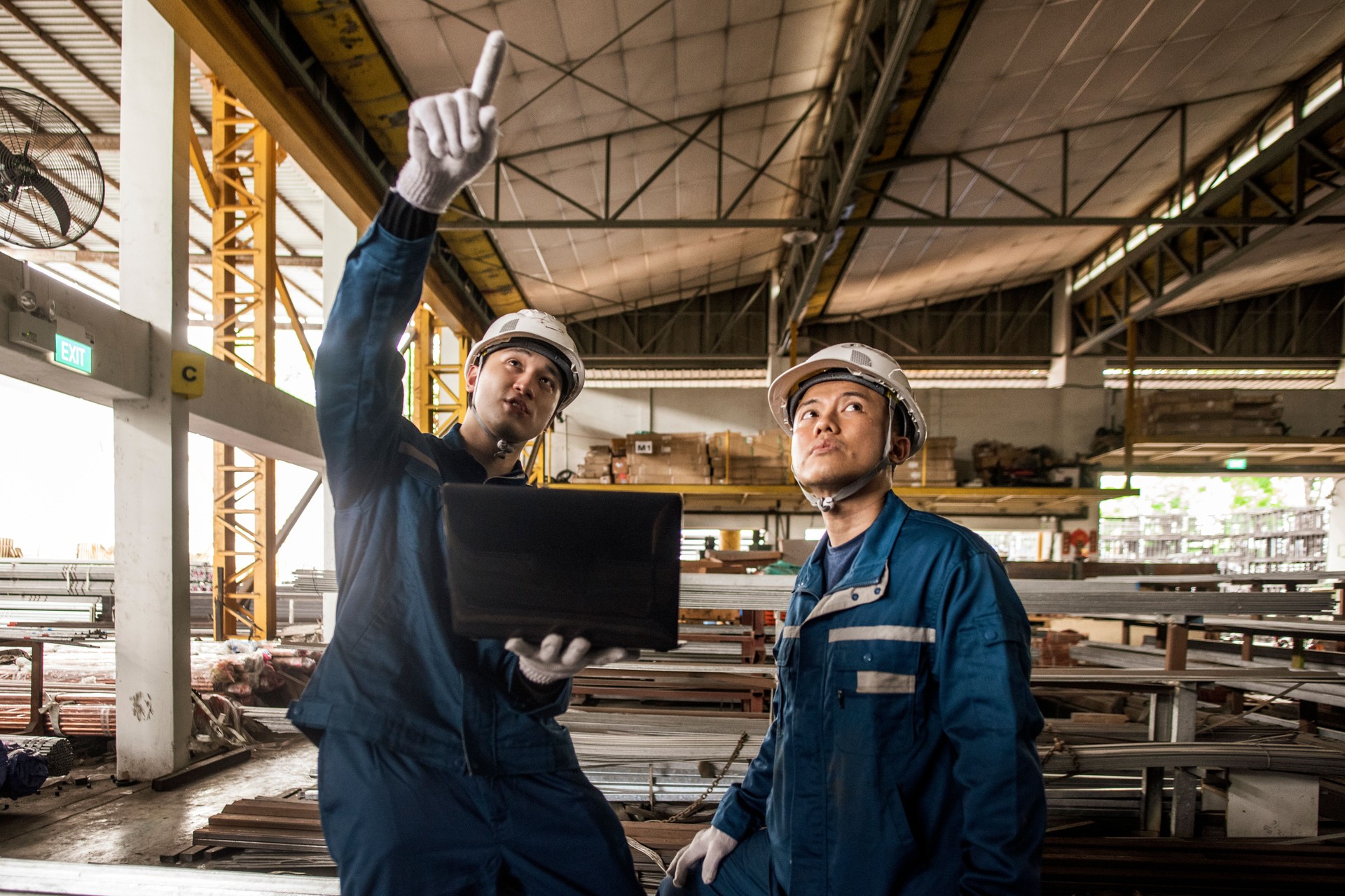 Asian workers at work using a laptop  in steel factory